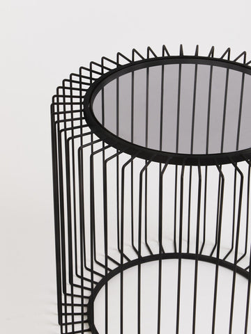 Black metal round side table with wireframe cylindrical base and mirrored glass top for modern living spaces