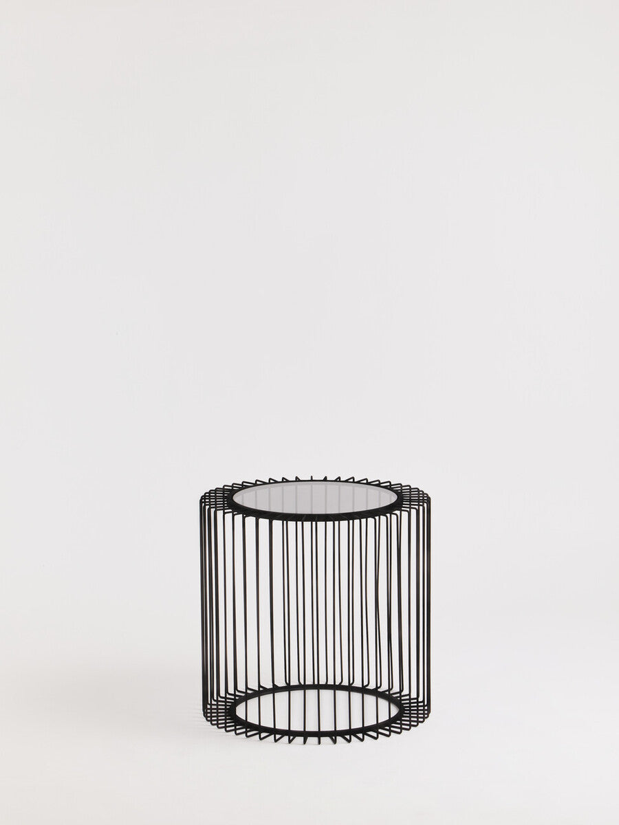 Black metal round wireframe cylindrical side table with clear glass top perfect for modern living spaces