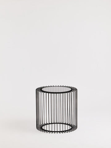 Black metal round wireframe cylindrical side table with clear glass top perfect for modern living spaces