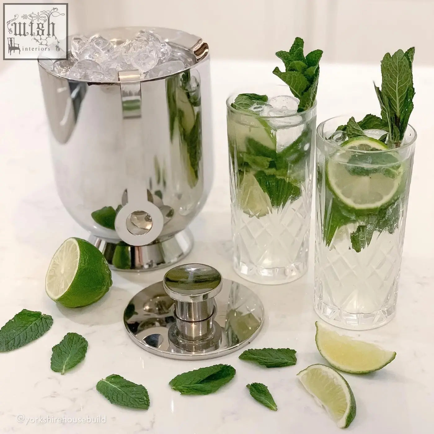 Shiny chrome cocktail shaker with built-in spout for easy pouring as part of trombone ice bucket set
