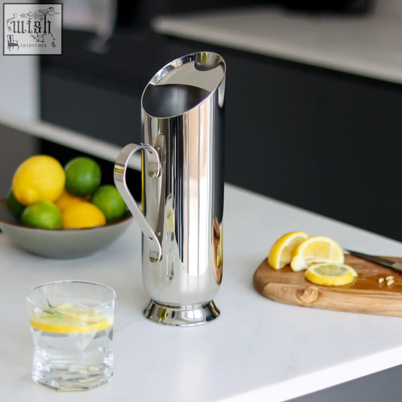 Shiny stainless steel trombone water pitcher with sleek modern design and curved handle for easy pouring