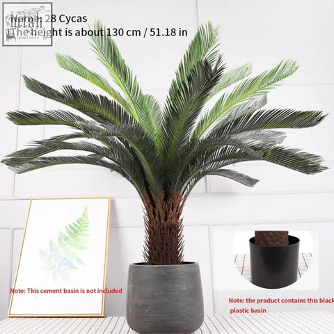 Tall tropical artificial palm tree with dark green plastic palm leaves and textured trunk in gray plastic pot for indoor use