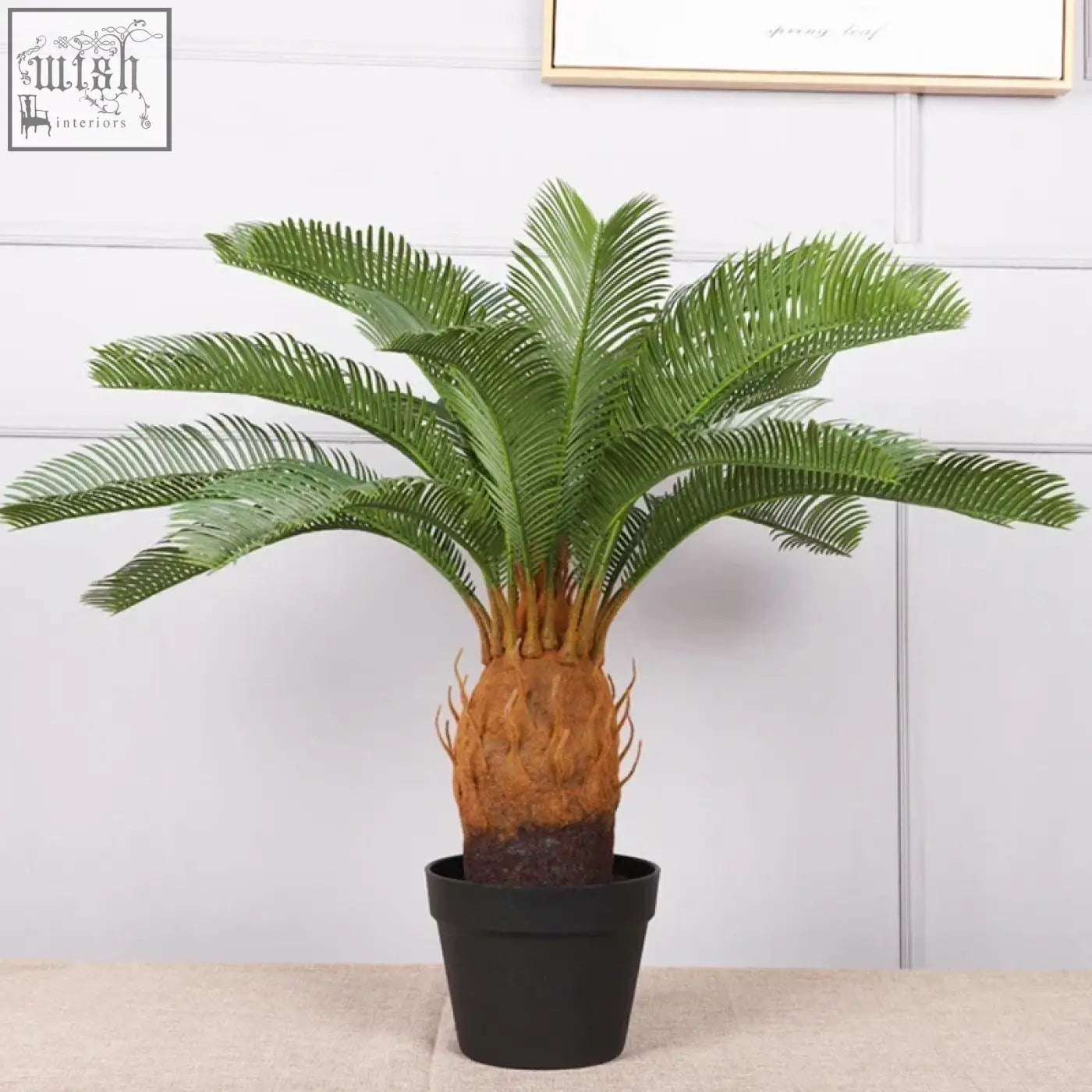 A lush tropical artificial palm tree with plastic palm leaves and a textured brown trunk in a black pot for decor