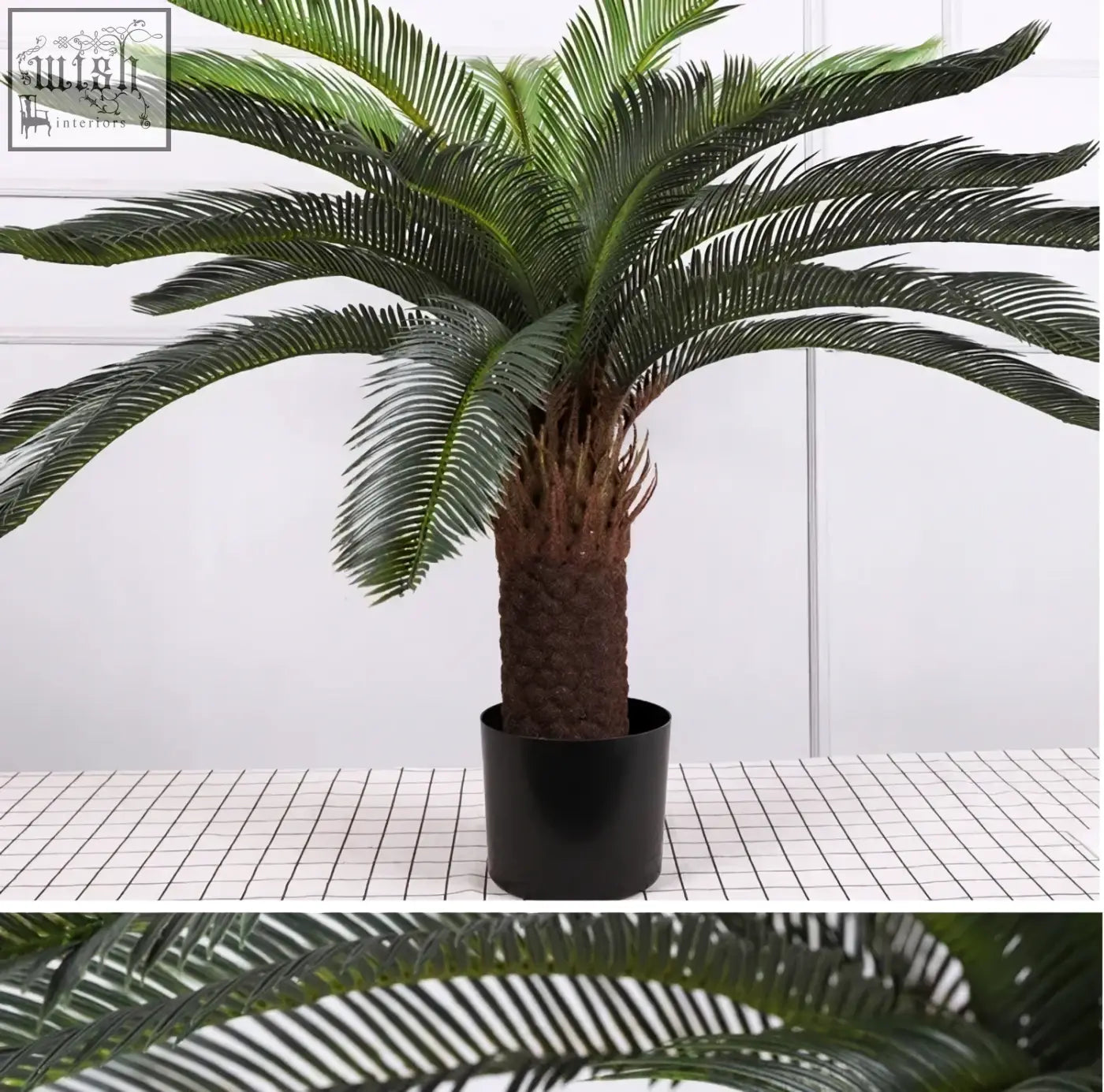 A lush tropical artificial palm with dark green plastic palm leaves and textured brown trunk in a black pot for indoor decor