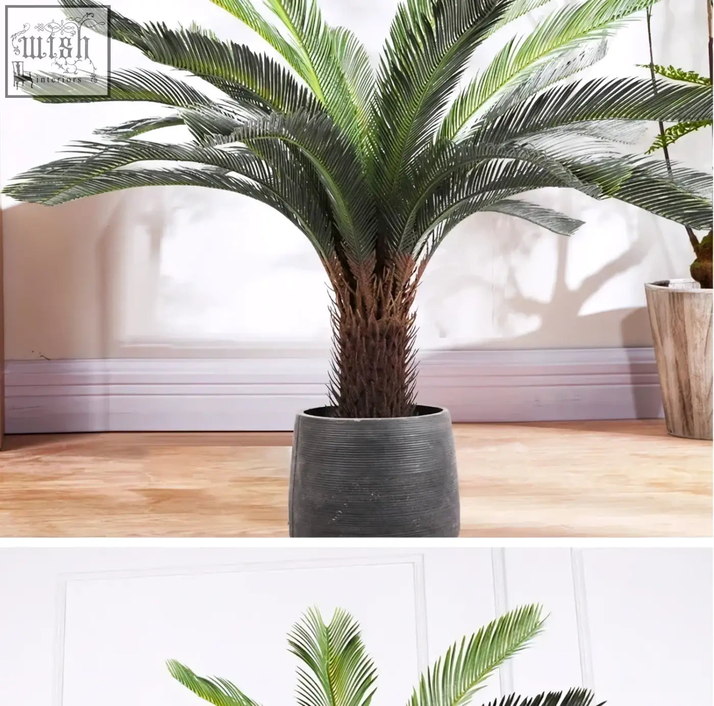 A lush tropical artificial palm with plastic palm leaves and a textured trunk in a dark gray ceramic pot for indoor decor