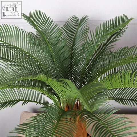 Green artificial cycad plant with detailed feathery fronds and textured brown trunk tropical artificial palm tree