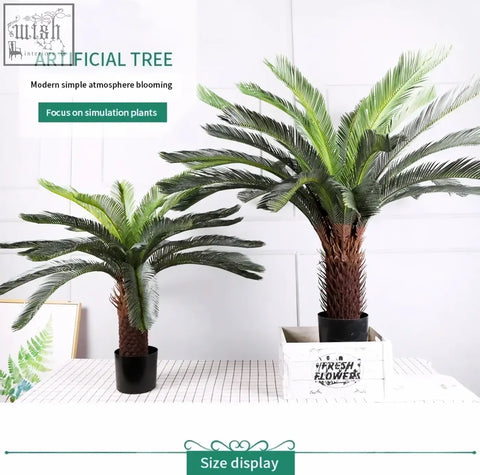 Two tropical artificial palm trees with green plastic palm leaves and brown trunks in black pot and white crate