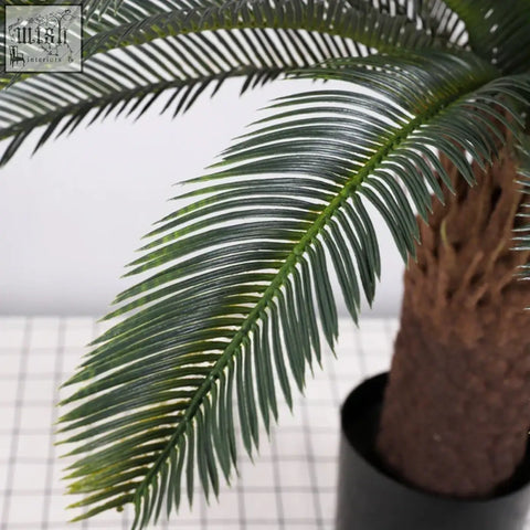 Dark green tropical artificial palm tree with detailed plastic palm leaves and textured brown trunk for decor