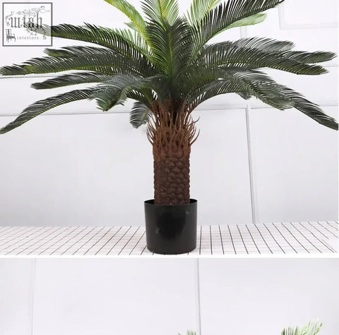 Realistic artificial palm tree with dark green plastic palm leaves and textured trunk in sleek black pot for decor