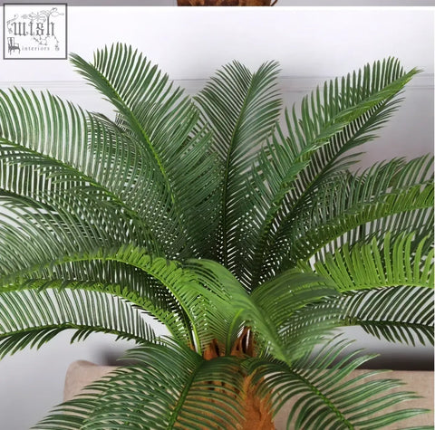 Artificial palm tree with detailed green plastic palm leaves and textured brown trunk for tropical decor