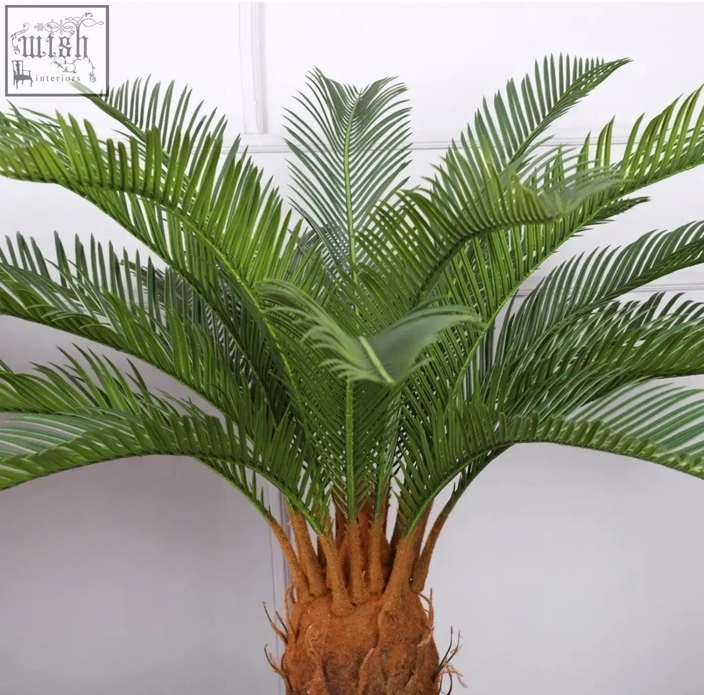 A lush tropical artificial palm with green plastic palm leaves and a textured brown trunk perfect for home or office decor