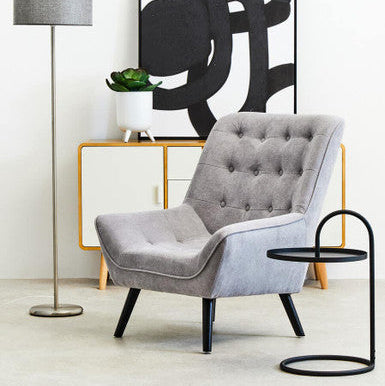 Gray tufted armchair with black legs paired with trosa black hanging top side table for stylish living space