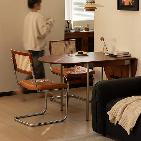 Brown leather-topped tsvetkov foldable dining table with chrome legs and solid wood woven cane backrest chair
