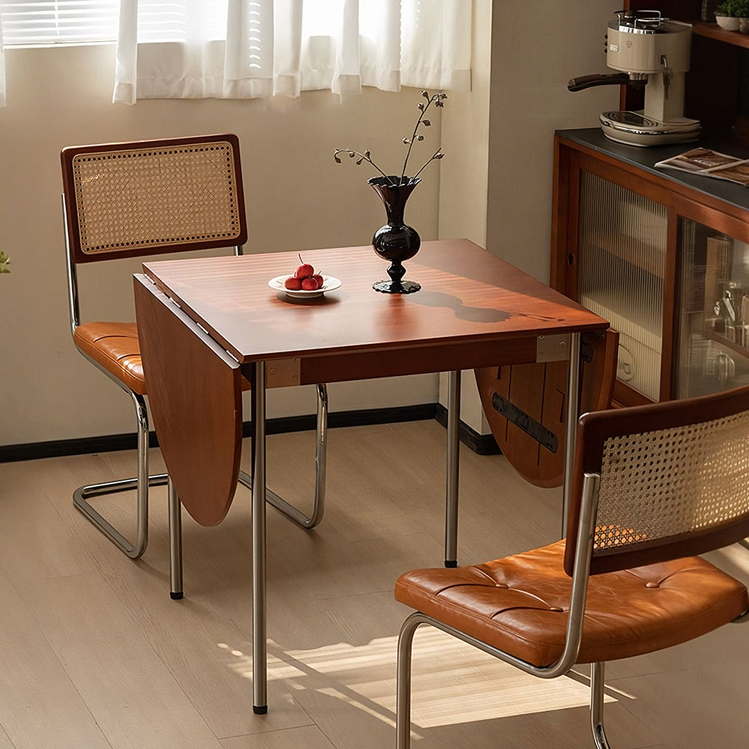 Brown solid wood tsvetkov foldable dining table with chrome legs and matching cane-backed chair visible from front