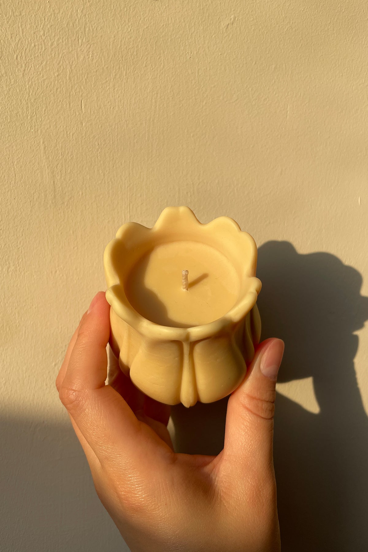 A pale yellow tulip shaped candle with smooth wax and delicate petal details perfect for home decor