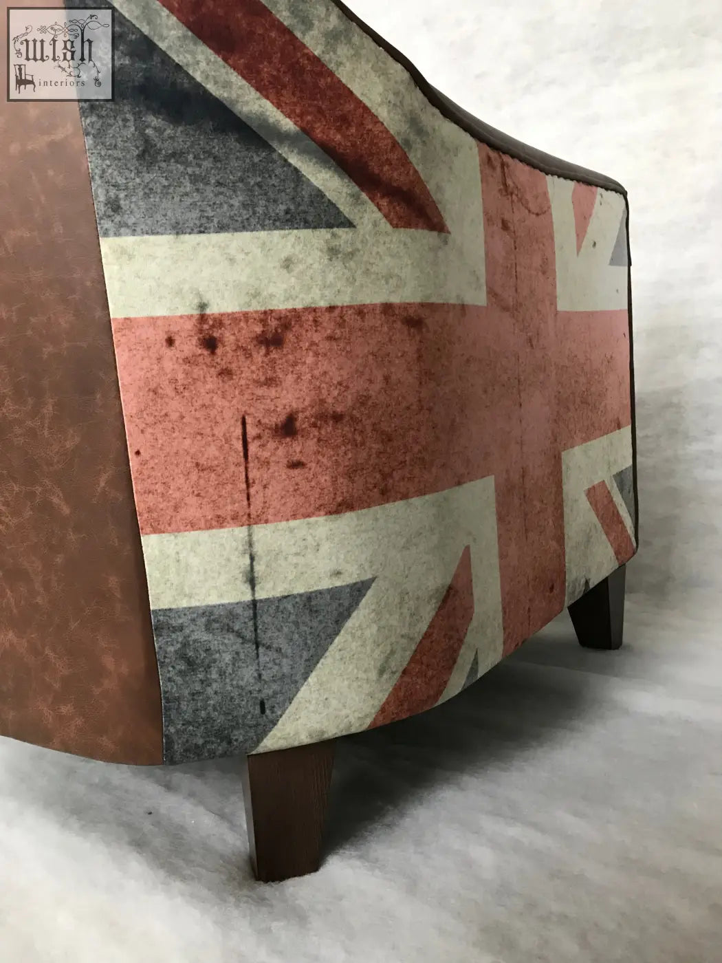 Vintage-style union tub chair with distressed union jack fabric in faded red white and blue upholstery