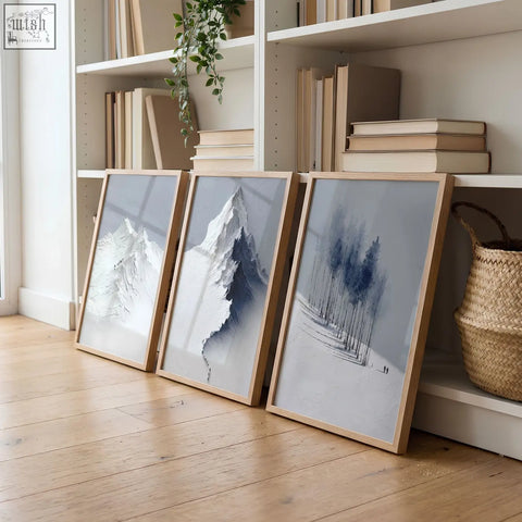 Three framed minimalist mountain landscape wall art prints in blue gray tones with light wood frames for living room