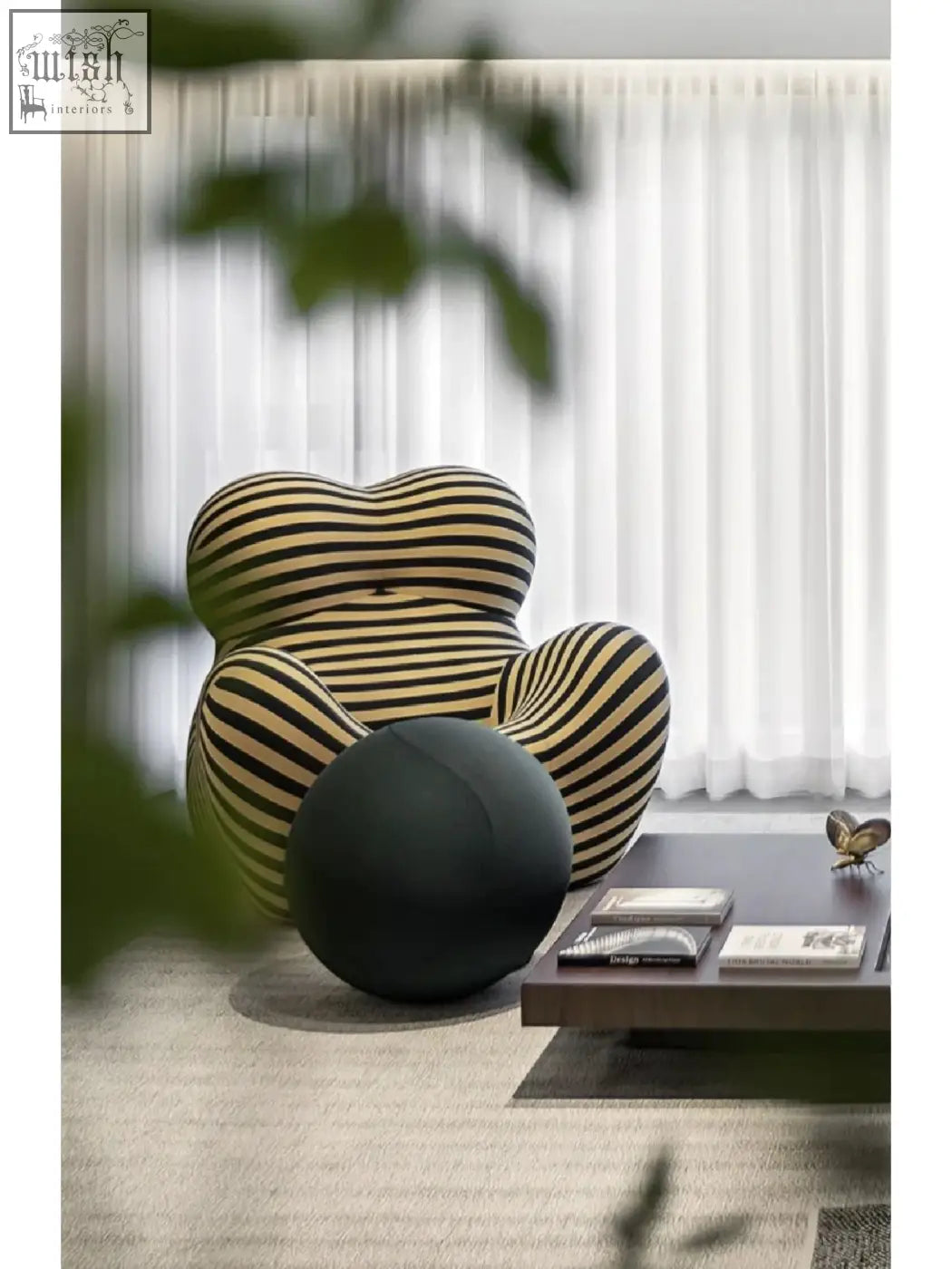 A plush up50 armchair lounge chair with bold black and beige stripes sits next to a sleek dark coffee table