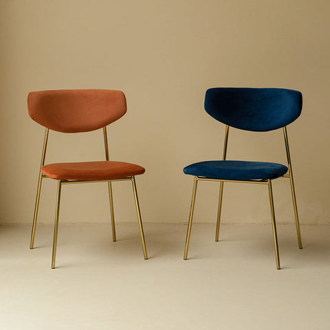 Modern urban dining chair with terracotta and navy blue velvet upholstery and slender gold metal legs