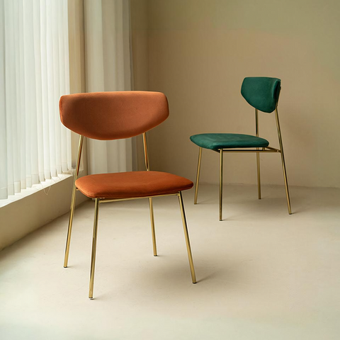 Modern urban dining chair with sleek gold metal frame and rich velvety orange velvet upholstery