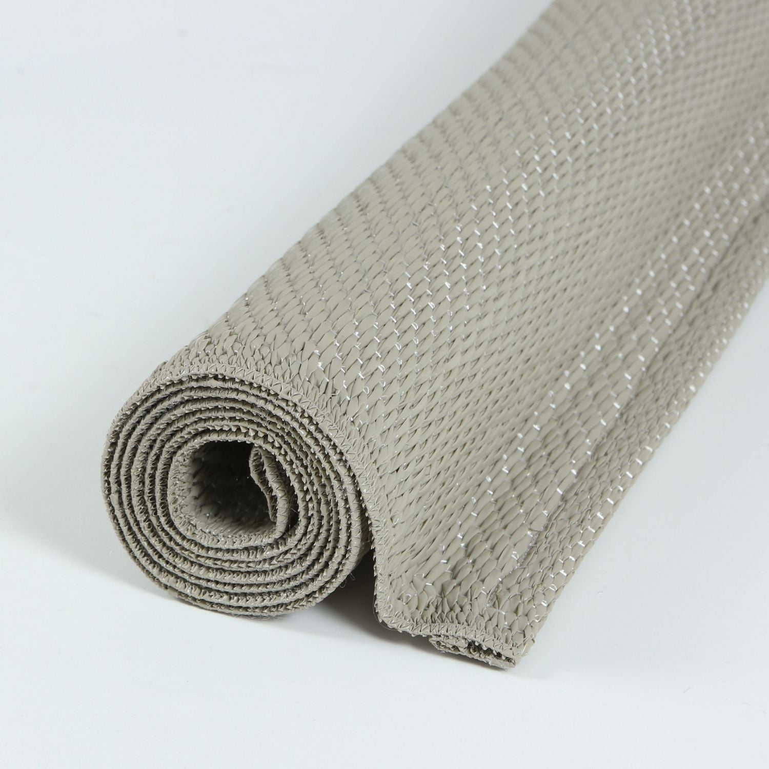 A rolled beige woven urban outdoor rug with a textured interlaced pattern perfect for outdoor use