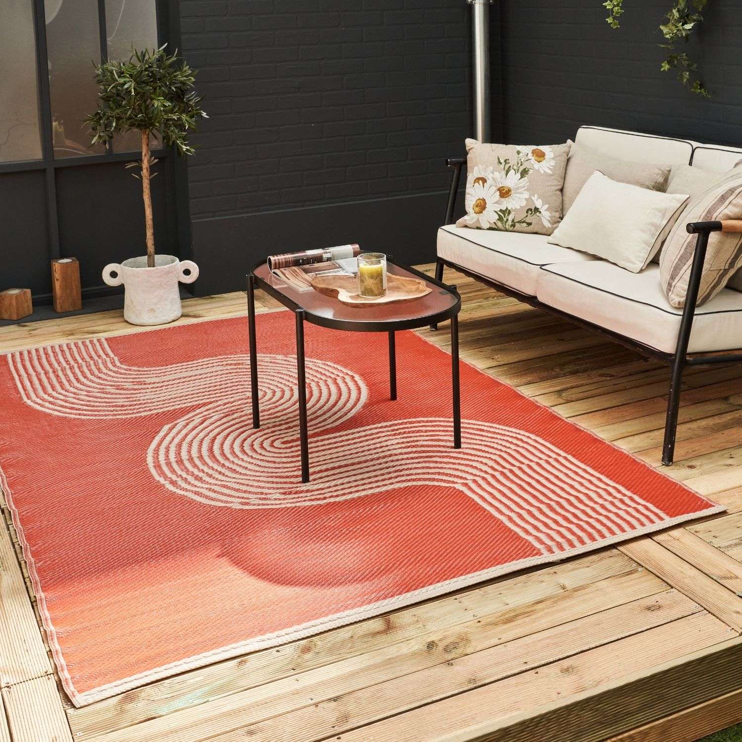 A vibrant coral-orange urban outdoor rug terra with modern cream wave pattern perfect for outdoor spaces