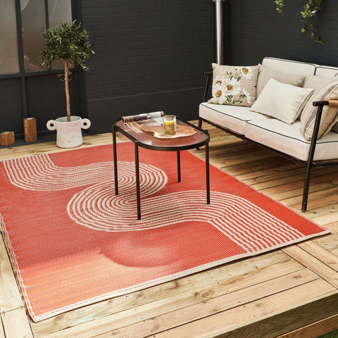A vibrant coral-orange urban outdoor rug terra with modern cream wave pattern perfect for outdoor spaces