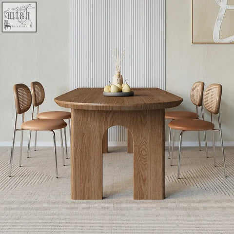 Light brown wooden uta dining table with rounded edges and distinctive arched center support for dining use