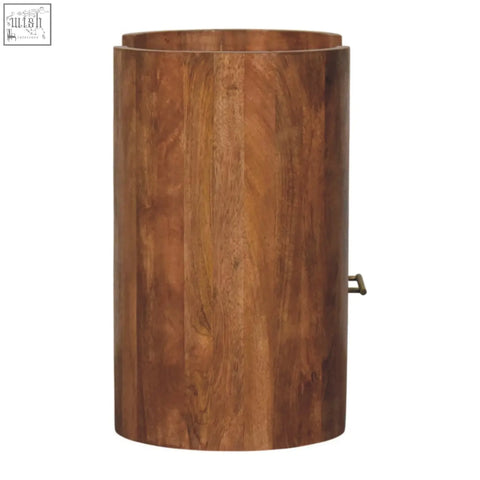 A cylindrical wooden trash can with warm brown finish and vertical grain for the valencia sculpted bedside