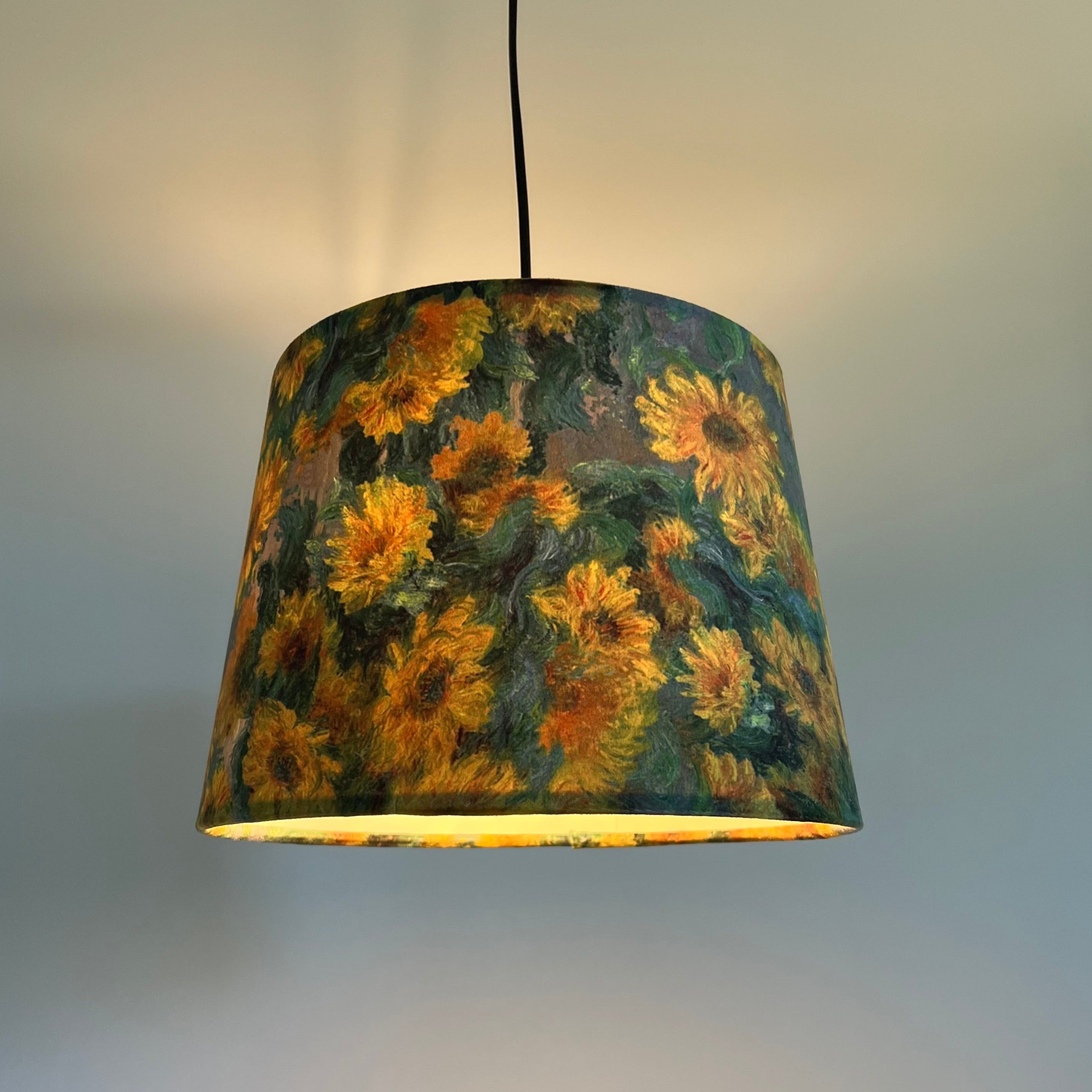 A handmade van gogh french drum lampshade with vibrant yellow sunflowers on dark green velvet and metallic brushed finish