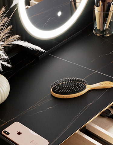 A sleek wooden hairbrush with black bristles and silver tips on a dark marble surface for vanity dressing table with led mirror black clearance