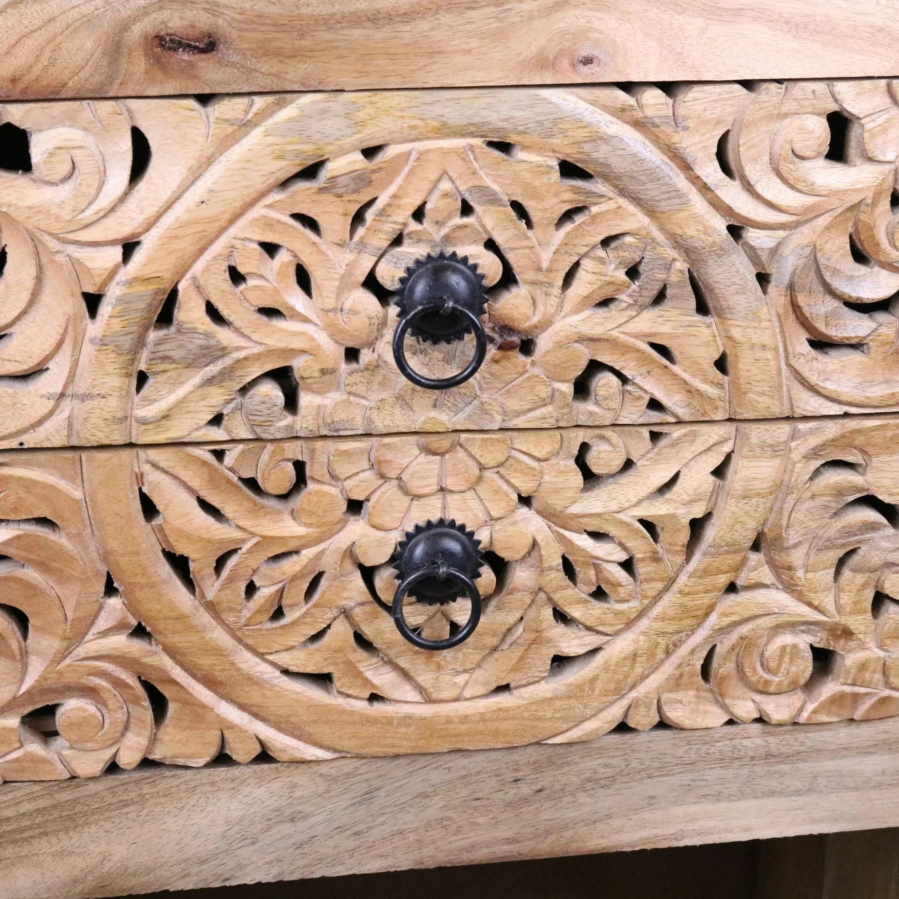 Light wood vansura carved bedside table with black metal ring pulls and intricate floral patterns and 2 drawers