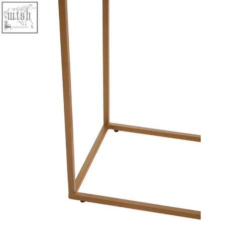 Gold iron frame of a varana console table featuring a black marble top in a modern minimalist design