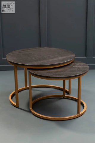Set of two black marble top round nesting coffee tables with dark wood and gold-toned metal frames