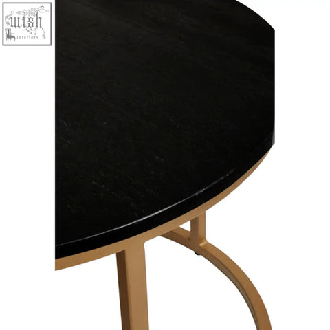 Black round table with sleek matte black marble top and slender gold legs from varana two black marble tables set