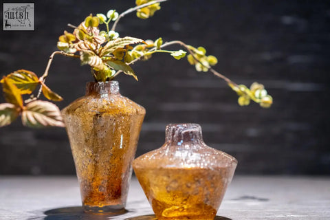 Two amber textured mouth blown glass vases with speckled finish and rounded necks from dutz collection