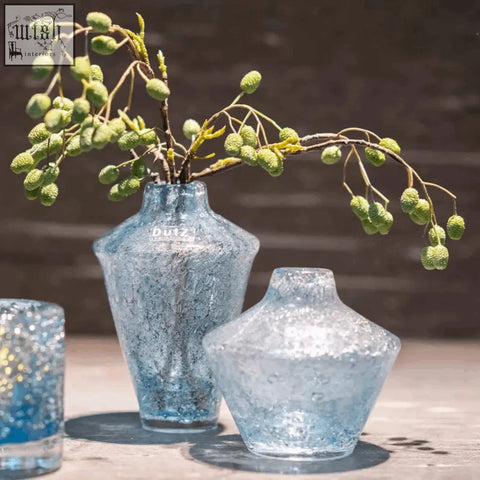 A translucent blue mouth blown glass vase from the dutz collection with a crackled surface and duyz logo