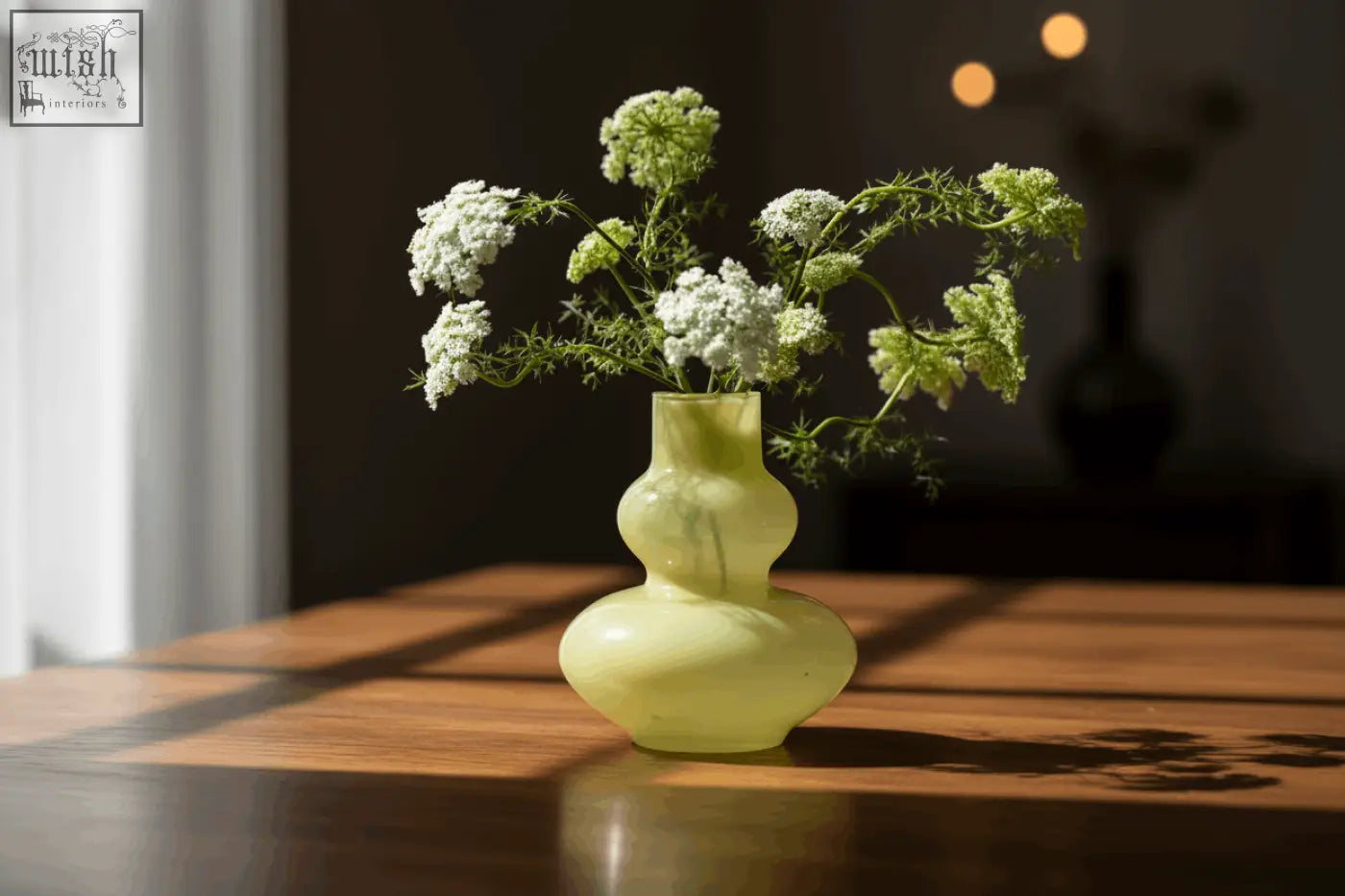 A mouth blown glass vase eldorad in translucent pale green from dutz collection holds delicate white flowers