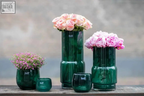 Emeral green mouth blown glass vase fenn from dutz collection with sleek ridges holding pink roses and purple flowers