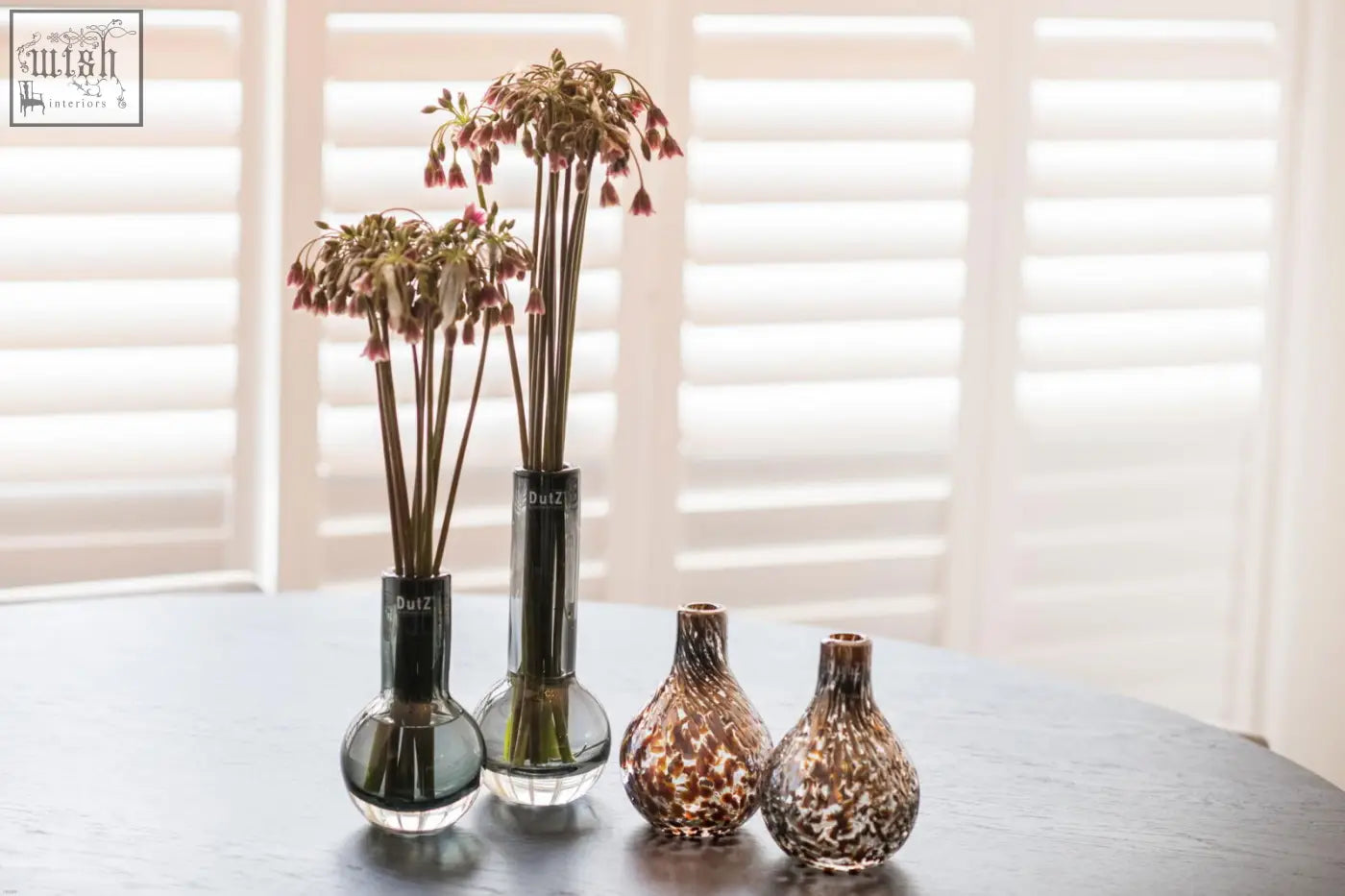 Three mouth blown glass vases from the dutz collection featuring a grey faceted base and two speckled brown designs
