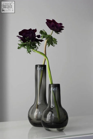 Two sleek dark gray mouth blown glass vases from the dutz collection with a modern slender design and dutz logo