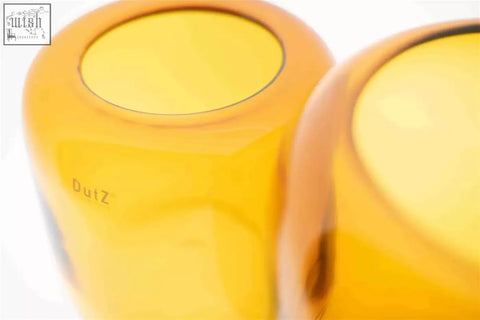 Yellow translucent mouth blown glass vases from dutz collection with smooth rounded design and duiz etched on the side