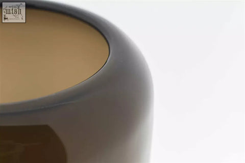 A sleek matte gray ceramic bowl with rounded rim and warm beige interior from dutz collection vase mazurka smoky brown