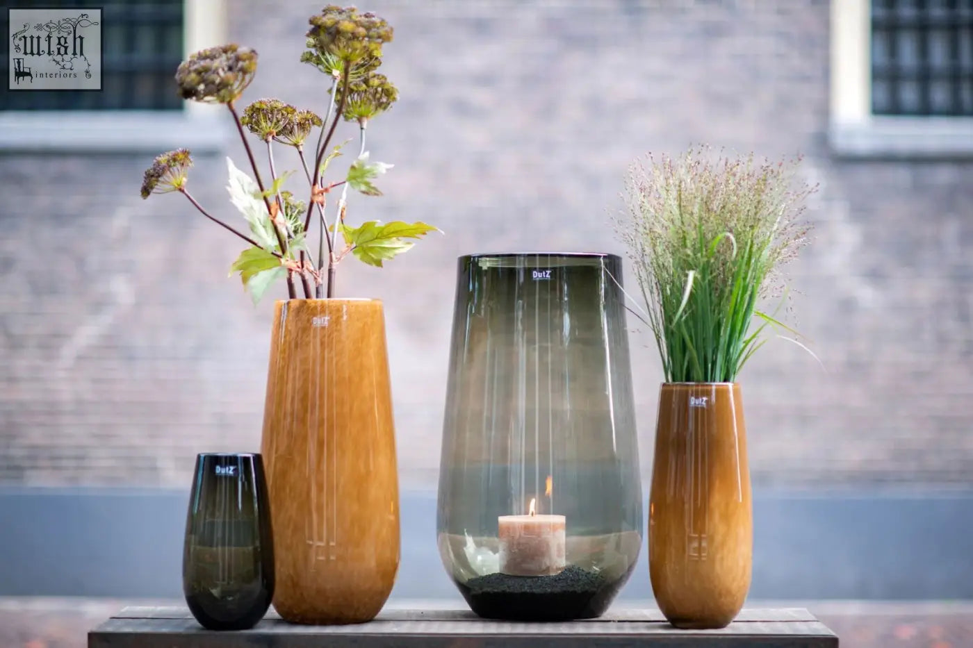 A sleek tall glass candle holder from dutz collection with dark gray gradient and mouth blown glass finish