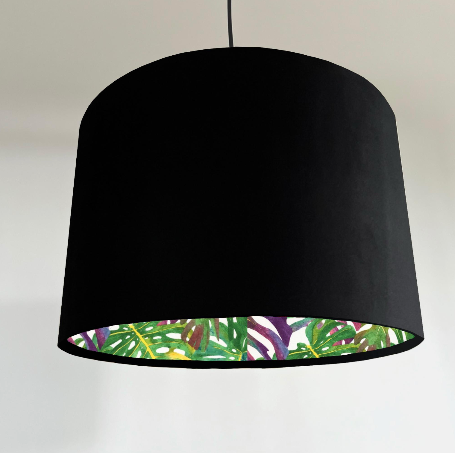 Black double sided drum lampshade with velvet exterior and vibrant tropical leaf pattern inside for ceiling light shade
