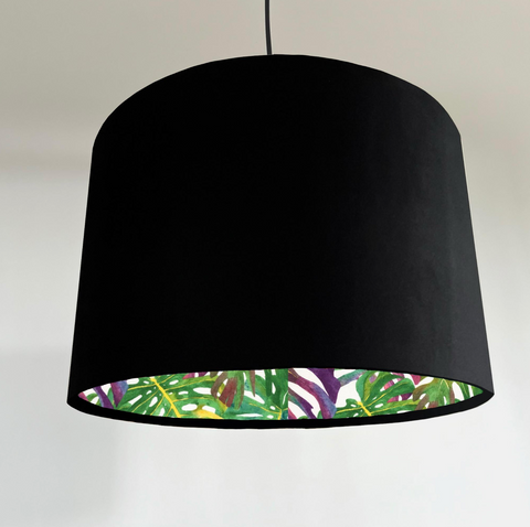 Black double sided drum lampshade with velvet exterior and vibrant tropical leaf pattern inside for ceiling light shade