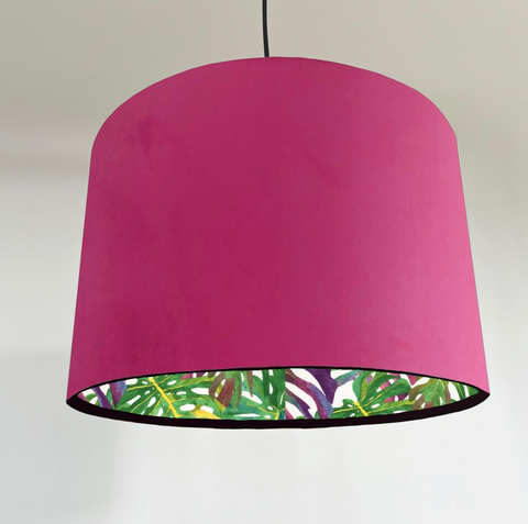 A vibrant fuchsia velvet double sided drum lampshade with tropical leaf lining for a handmade ceiling light shade