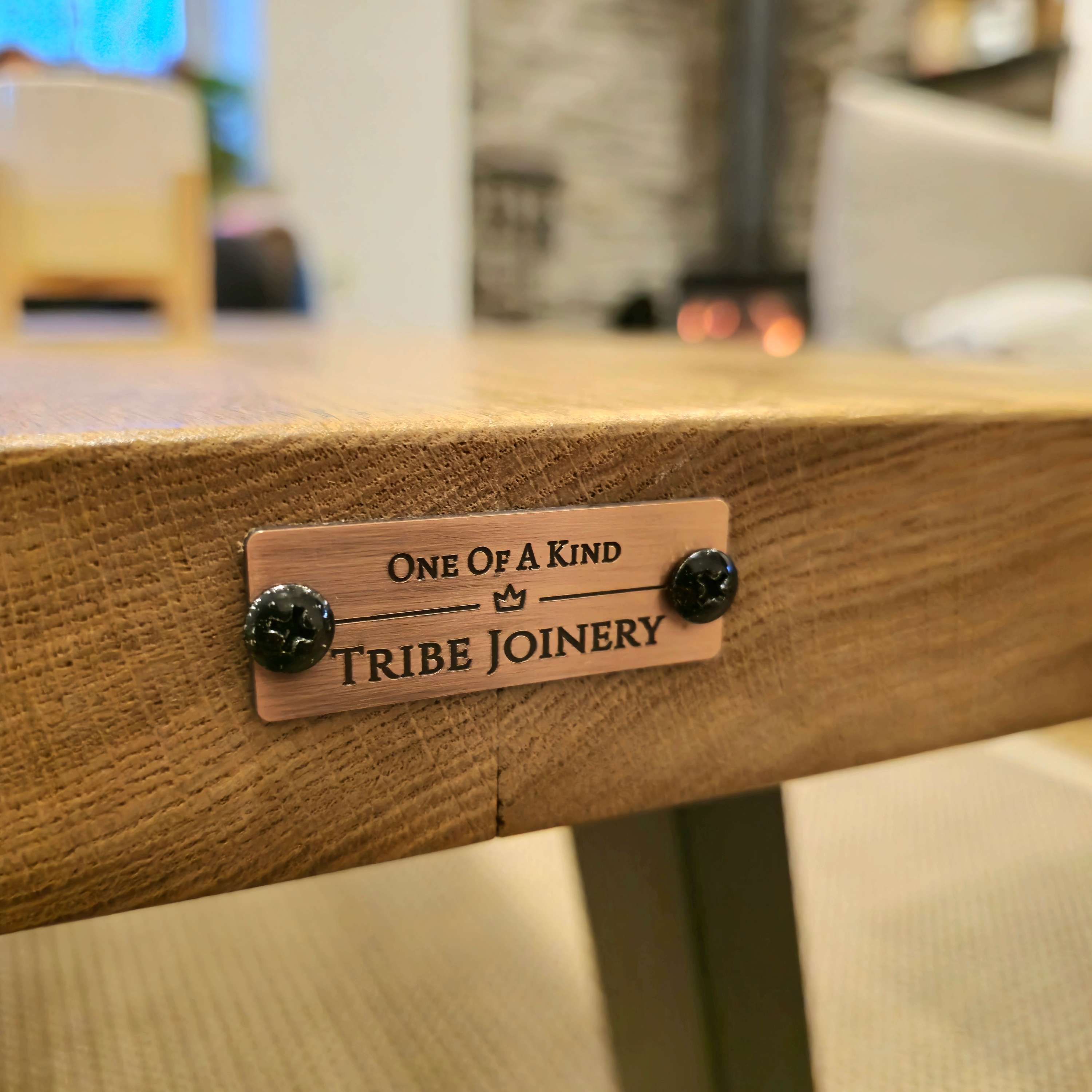 A bronze plaque with tribal joinery engraving on the back of the vena live waney edge coffee table edge coffee table