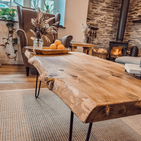 A rustic vena live edge coffee table with natural wood finish and black metal hairpin legs perfect for edge coffee