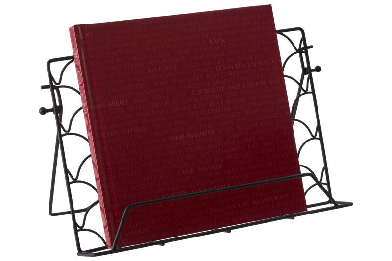 A deep red hardcover book displayed upright in a vertex deco black wrought iron cookbook stand